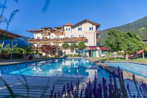 um hotel com piscina em frente a um edifício em Hotel Untermelz em Plaus