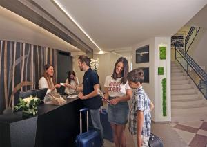 a group of people standing around a counter in an office at Residence Continental Resort in Gabicce Mare