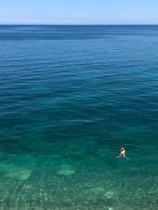 a person swimming in a large body of water at Vignanotica Beach Apartments in Mattinata