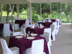 una fila de mesas y sillas con manteles púrpura y blanco en Hotel Chapala Country en Chapala