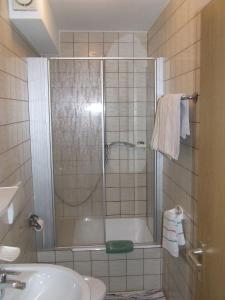 y baño con ducha, bañera y lavamanos. en Pension Sonnenhof, en Bischofsmais