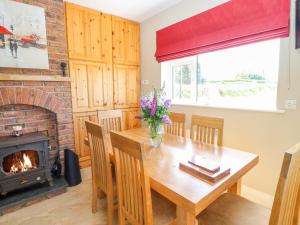 a dining room with a table and a fireplace at Sea View Hideaway in Milltown Malbay
