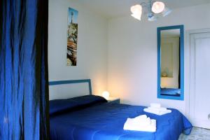 オートラントにあるCamere Borgoのベッドルーム(青いベッド1台、鏡付)
