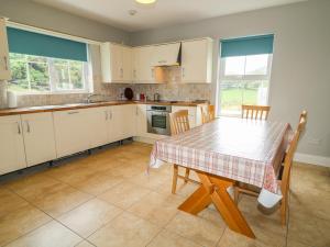 a kitchen with a table and chairs and windows at Croghan in Fanad