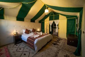 a bedroom with a bed in a circus tent at Sahara Desert Luxury Camp in Merzouga