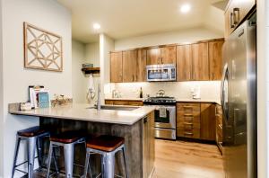 a kitchen with wooden cabinets and stainless steel appliances at THE PENDLETON in Eugene