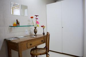 奧林達的住宿－Casa Mirar Recife de Olinda，一张带花瓶和椅子的桌子