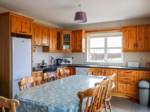 una cucina con tavolo e alcuni armadi in legno di Doornogue a Fethard-on-Sea