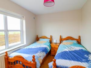 2 camas individuais num quarto com uma janela em Doornogue em Fethard-on-Sea