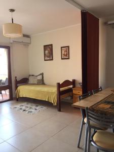 Un dormitorio con una cama y una mesa y sillas. en RS Las Grutas, en Las Grutas