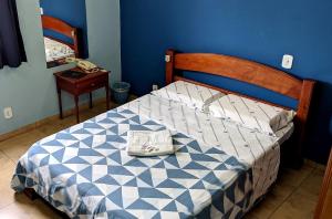 um quarto com uma cama com uma parede azul em LM Hotel em São Paulo