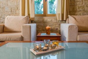 een woonkamer met een glazen tafel met kaarsen erop bij Enastron Villas in Kyparissia