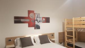a bedroom with a bed and a cross on the wall at THAT'S AMORE FIUMICINO Airport in Fiumicino