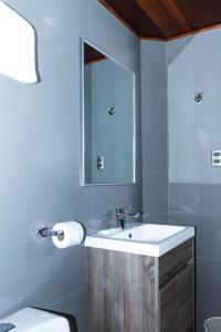 uma casa de banho com um lavatório, um espelho e um WC. em Hotel Santa Cruz em Huaraz
