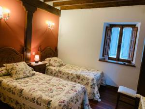 a hotel room with two beds and a window at La Posada de Abanillas in Abanillas