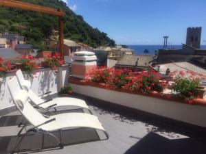 un grupo de sillas sentadas en un balcón con flores en SoleMare, en Monterosso al Mare
