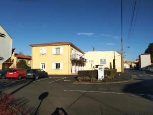 een geel gebouw op een straat met een parkeerplaats bij logis SAINT AUSTREMOINE in Issoire
