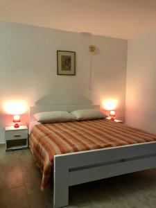 a bedroom with a bed with two lamps on two tables at Anita studio 3 Apartment in Mali Lošinj