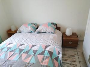 a bedroom with a bed with a colorful comforter and pillows at logis SAINT AUSTREMOINE in Issoire