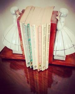 Una fila di libri su uno scaffale con sopra delle bambole di I Naviganti a Taormina