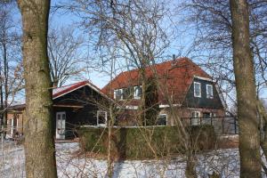 una casa con techo rojo en el bosque en B&B 't Lierderholt, en Lierderholthuis