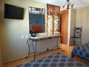 HuichapanにあるHotel Santa Barbaraの鏡付きのテーブルとベッドが備わる客室です。