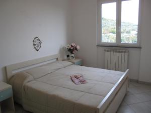 Un dormitorio con una cama grande y una ventana. en Appartamenti Tra gli Ulivi, en Bardino Nuovo