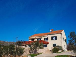 uma grande casa branca com um telhado vermelho em Villa Antonija em Čilipi