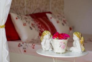 two angel figurines on a table with a basket of flowers at Villa Antonija in Čilipi