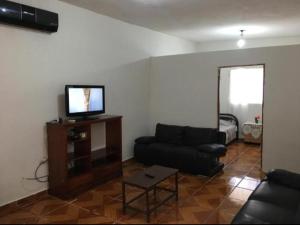 un soggiorno con divano e TV a schermo piatto di Casa 4-100-egas a Cuatrociénegas de Carranza