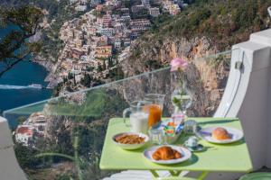 a table with plates of food on top of a mountain at Bacio del Sole B&B Positano in Positano