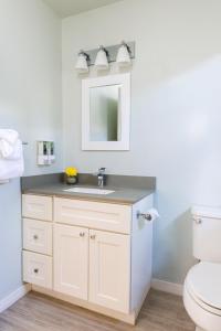 ein Badezimmer mit einem weißen Waschbecken und einem Spiegel in der Unterkunft Diablo Mountain Inn Walnut Creek in Walnut Creek