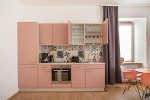 a kitchen with pink cabinets and a table and chairs at Apartment 6 in Stockach