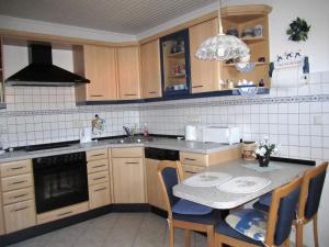 a kitchen with a sink and a table with chairs at Apartment near the forest in Hullersen in Einbeck