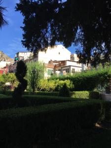 a large white building in the middle of a garden at I Naviganti in Taormina