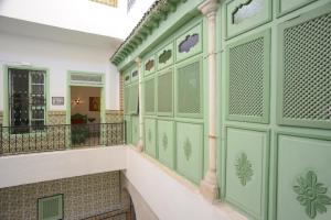 a building with green doors and a balcony at Dar Ya in Tunis