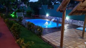 a pool with a water slide in a yard at night at Pousada Brasil in São Miguel do Gostoso