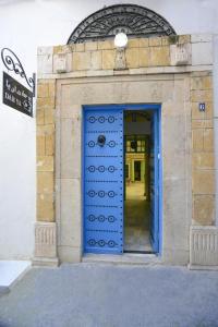 a blue door on a building with a sign at Dar Ya in Tunis