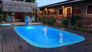 a swimming pool with a water fountain in a yard at Pousada Brasil - São Miguel do Gostoso in São Miguel do Gostoso