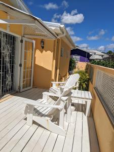 a deck with two lounge chairs and a table at Anne's Villa in Christ Church