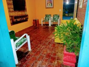 a room with a brick floor with chairs and a fireplace at Pousada Don Robledo in São Miguel dos Milagres