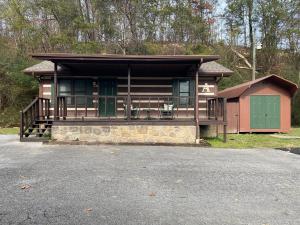 a small cabin with a green door and a porch at On Dolly Time 1 mile from Dollywood in Pigeon Forge
