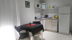 a kitchen with a table and chairs and a white refrigerator at Aloha VI - El Palomar in El Palomar