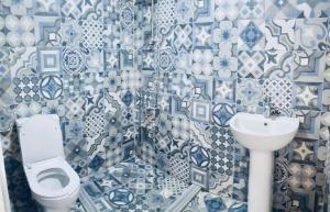 a blue and white bathroom with a toilet and sink at Jordan Tower Hotel in Amman