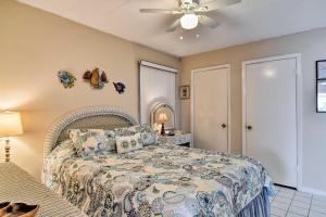 a bedroom with a bed and a ceiling fan at Less Than 2 Mi to Upham Beach Colorful Bungalow with Pool in St Pete Beach +16 photos