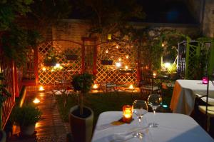 a patio with tables and candles and lights at L'Hôtel Le Cheval Noir in Moret-sur-Loing
