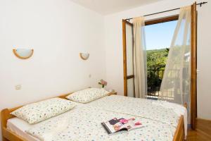 Schlafzimmer mit einem Bett und einem Fenster in der Unterkunft Apartments Marija in Sukošan