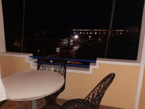 a table and chairs on a balcony at night at Latanier Beach Hotel in Grand-Baie