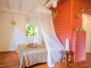 a bedroom with a bed with a mosquito net at L'Îlot Palmiers in Pointe-Noire