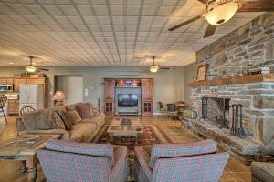 sala de estar con sofá y chimenea de piedra en Family and Fisherman Friendly Home on Beaver Lake!, en Garfield